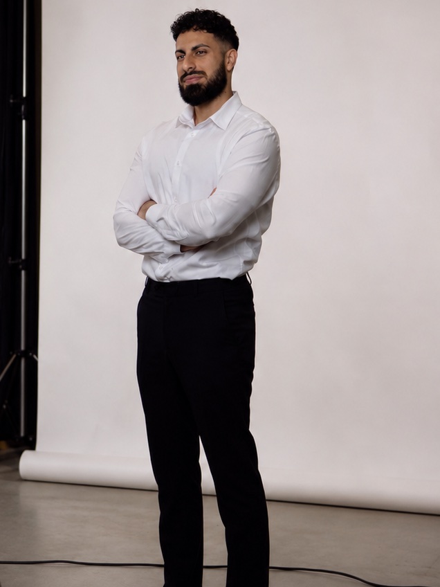 Navid Sobat im Studio vor weißem Hintergrund, mit verschränkten Armen