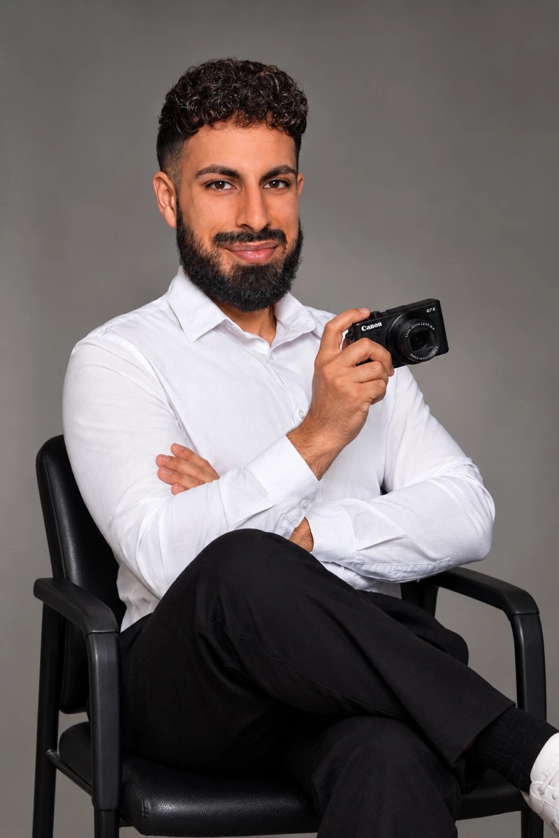 Navid Sobat mit Kompaktkamera in der Hand